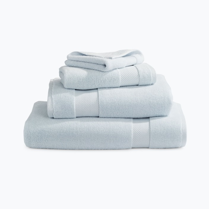 Three neatly stacked towels, one on top of the other, ready to be used.