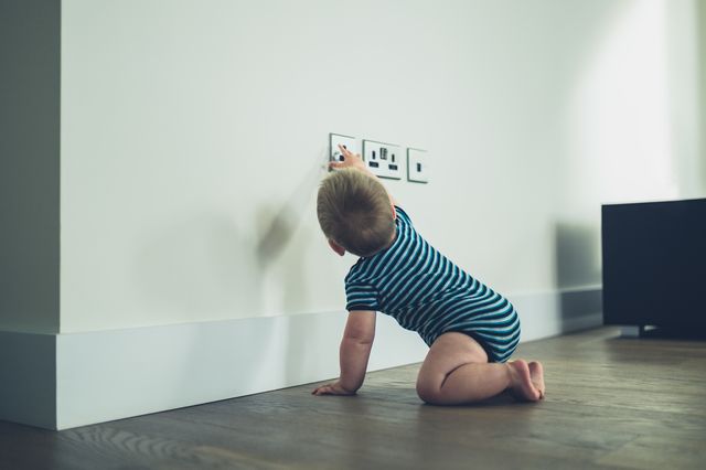 How to Baby Proof Your Home Before Baby is Born, Crawling baby playing with electrical outlet.