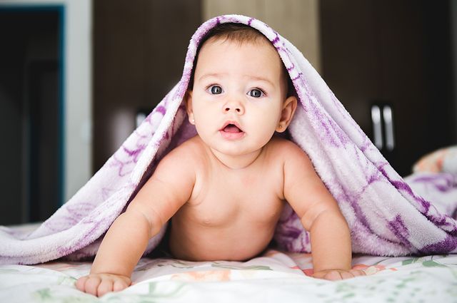Best Sound Machines to Soothe a Fussy Newborn, baby under a purple blanket