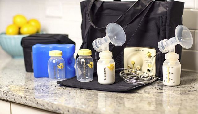 breast_pump, picture of medela baby bottles with the breast pump system and bag in the background sitting on a countertop