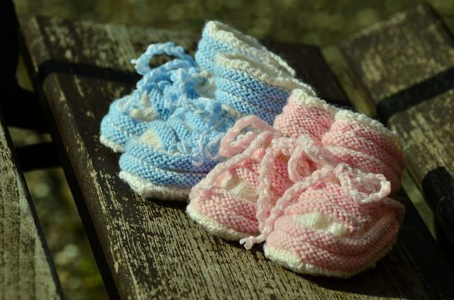 Best Registry Items For Twins, Two sets of newborn shoes, one pair blue and the other pair pink.