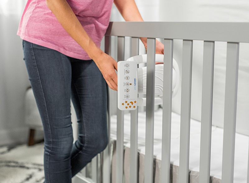 The Halo SnoozePod: Must-Have Baby Product of 2018, woman setting up the Halo SnoozyPod onto her child's crib.