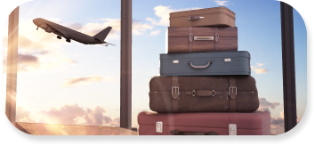 A stack of five pieces of luggage sit in front of a large window with an airplane taking off outside.