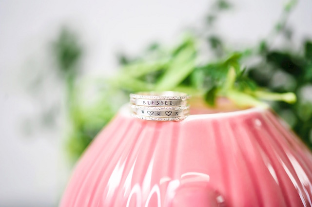 The Perfect Jewelry for All Your Wedding Occasions, image of custom, silver wedding rings on a pink bowl.